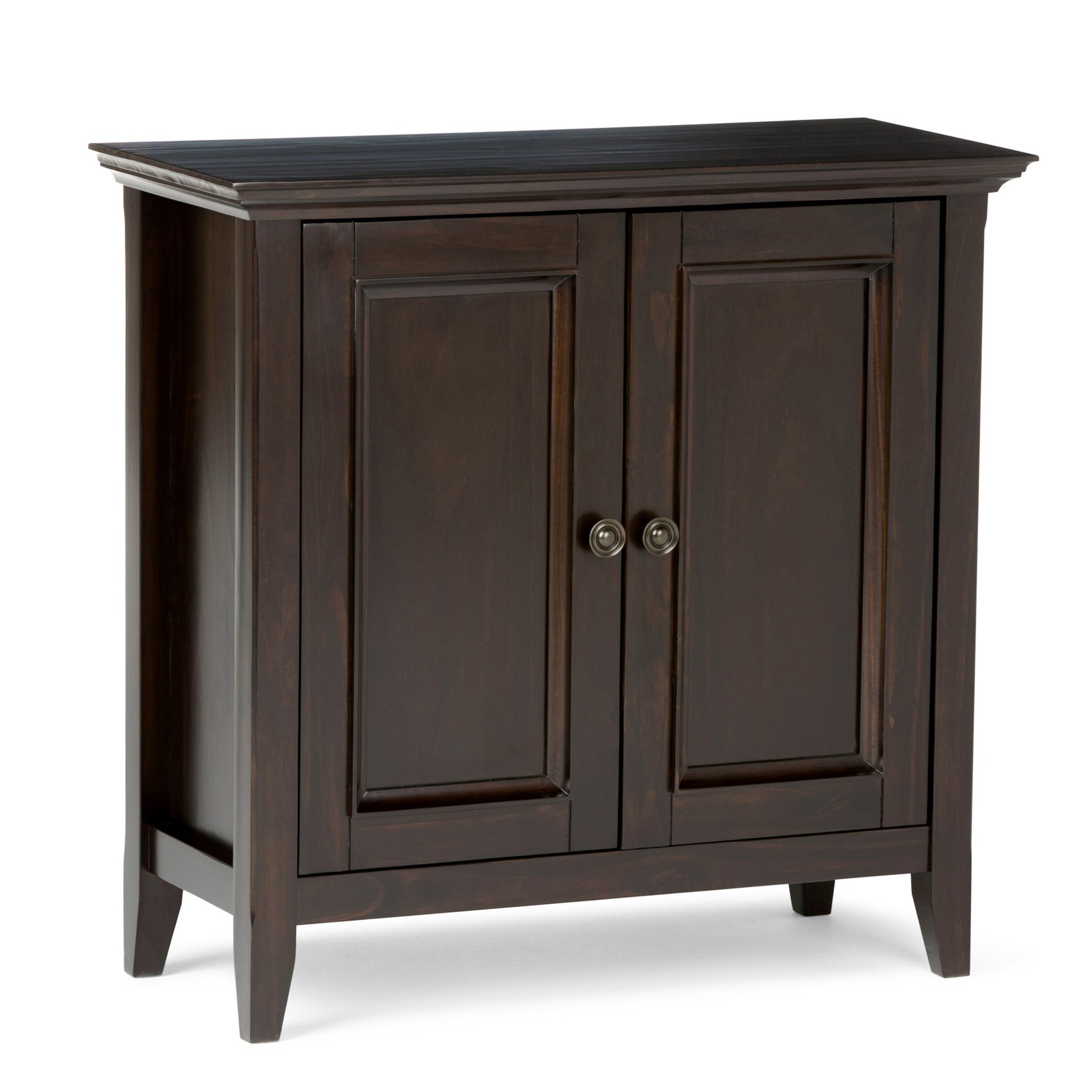 The Amherst - Handcrafted Low Storage Cabinet features dark wood, two paneled doors with round metal handles, and four short legs. Its simple, classic design fits seamlessly into a variety of home interiors.