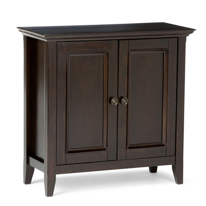 The Amherst - Handcrafted Low Storage Cabinet features dark wood, two paneled doors with round metal handles, and four short legs. Its simple, classic design fits seamlessly into a variety of home interiors.