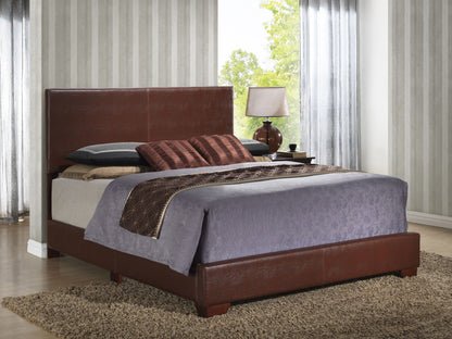A modern bedroom features the Elegant Platform Bed For Relaxed Spaces, neatly made with gray and brown bedding, accent pillows, a side table with a lamp, and large windows with sheer curtains letting in daylight.