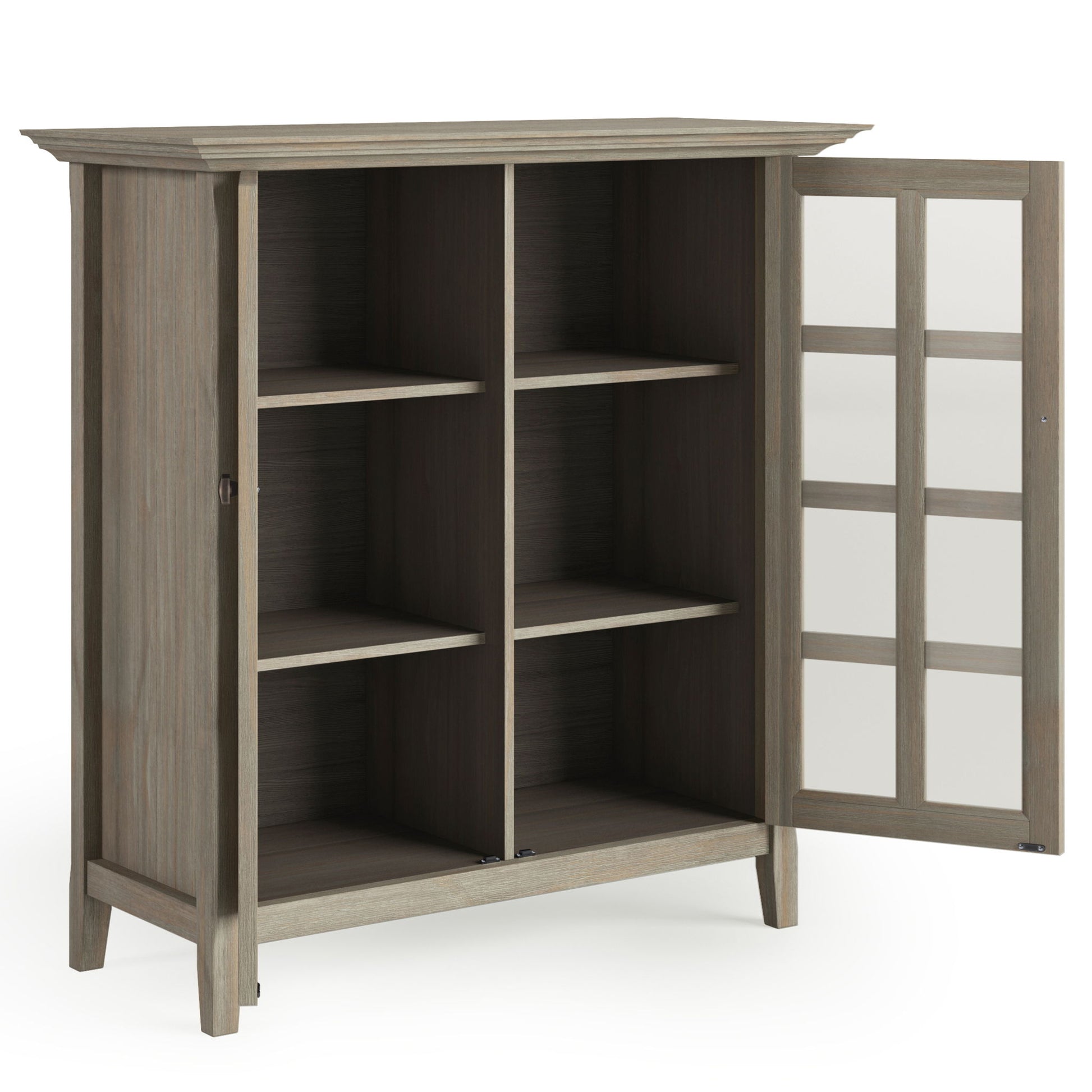 The Acadian - Medium Storage Cabinet, Handcrafted, features four shelves and a glass-paned door. It stands on four short legs and showcases a natural wood finish, offering stylish interior storage compartments.
