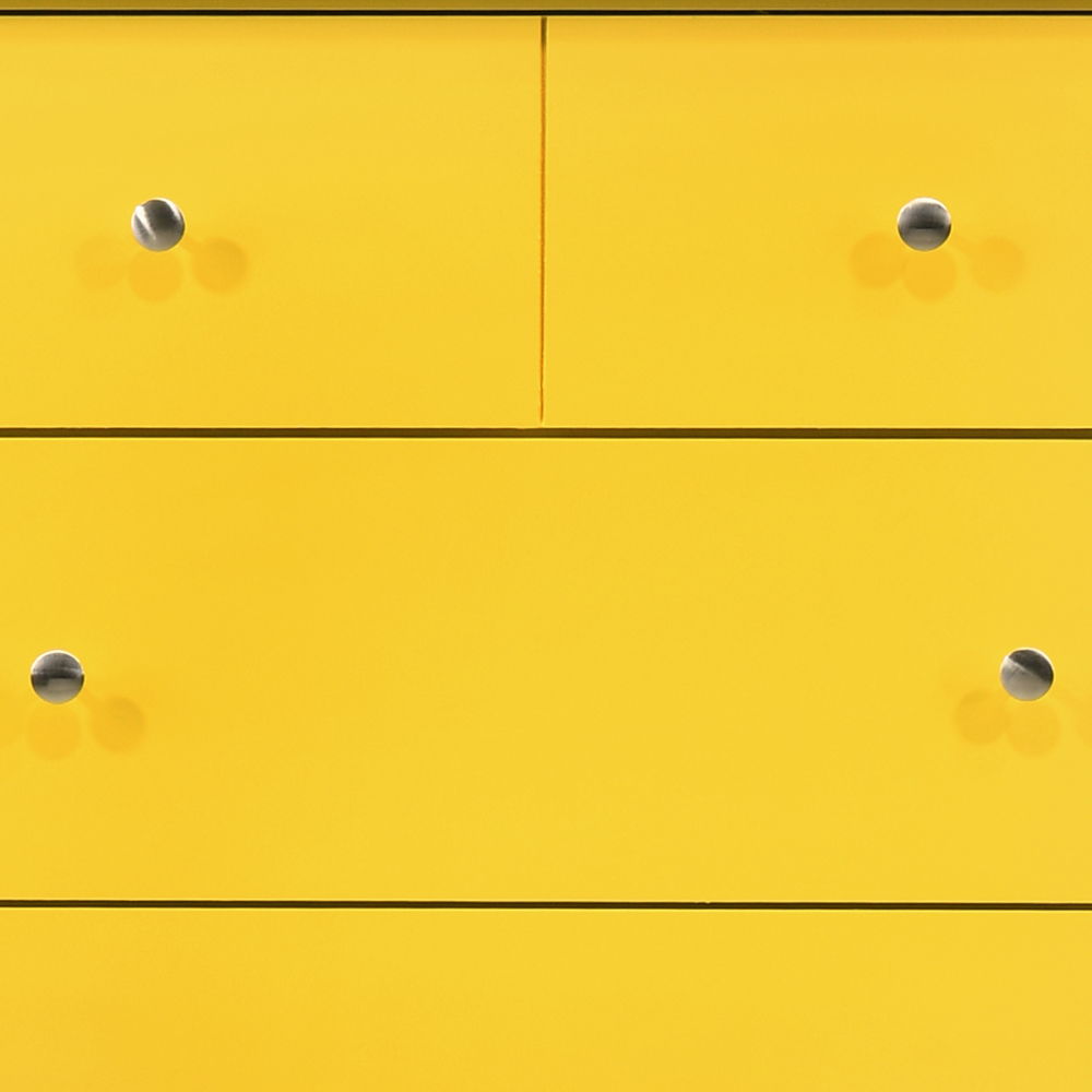 Close-up of the Hammond Chest, a yellow minimalist dresser featuring two small drawers on top and two larger ones below, all with round silver knobs and a smooth surface.