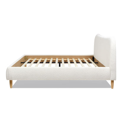 The Roman - Curved Headboard Upholstered Platform Bed features a modern, low-profile design with a textured white upholstered headboard and sides, wooden slats for support, and short light wood legs, displayed side view against a white background.