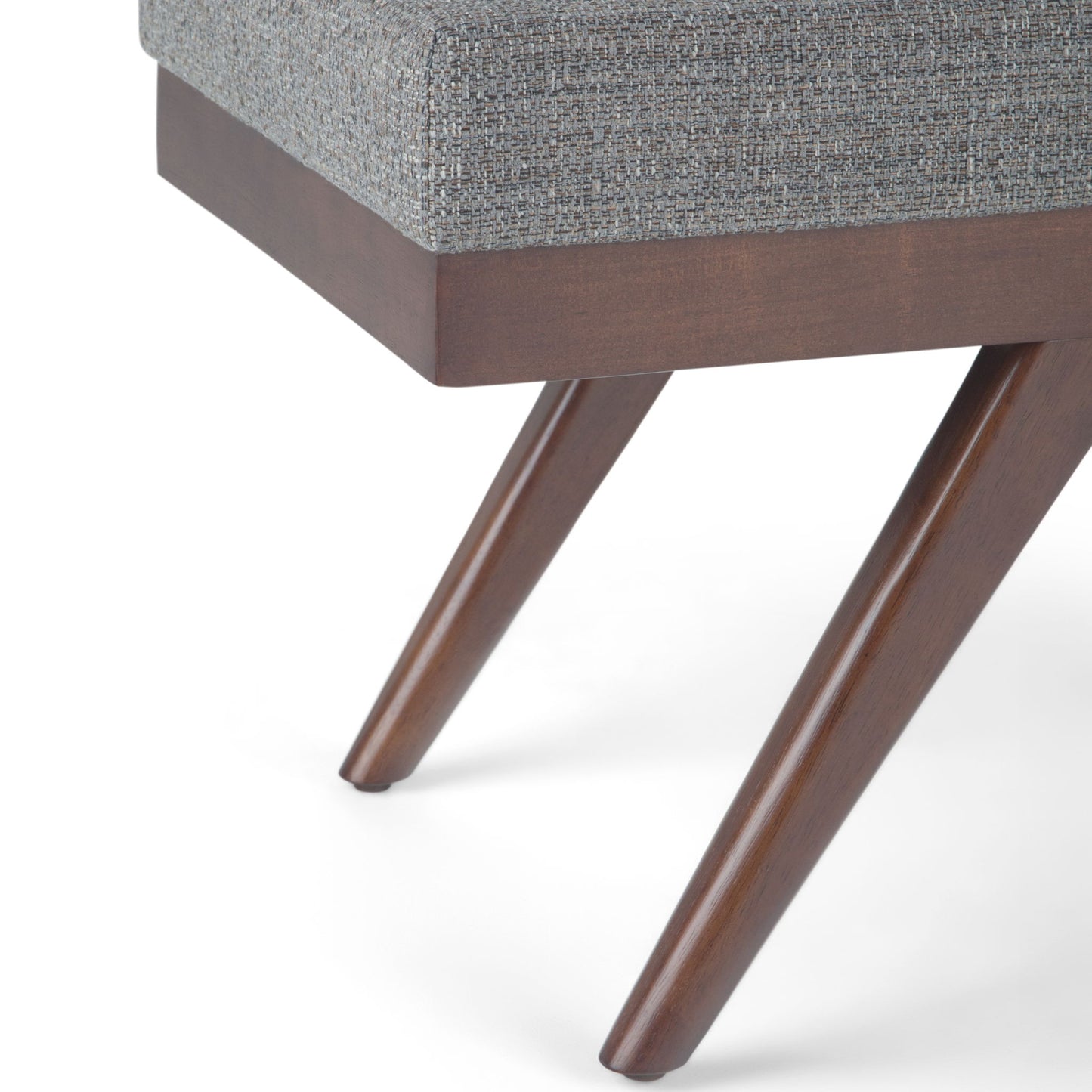 Close-up of the Chanelle - Mid-Century Ottoman Bench featuring angled wooden legs and a gray upholstered cushion, set against a white background.
