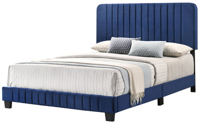 The Lodi - Bed features a tall, vertical-stitched blue upholstered headboard and matching frame, accented with white and gray plaid bedding, a beige blanket, and multiple patterned pillows for a modern look.