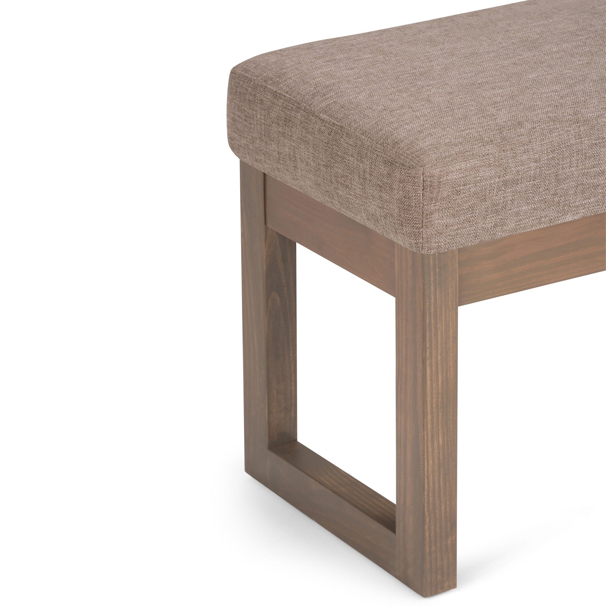 Close-up of the Milltown - Upholstered Ottoman Bench featuring a cushioned light brown fabric seat and rectangular open-frame wooden leg.