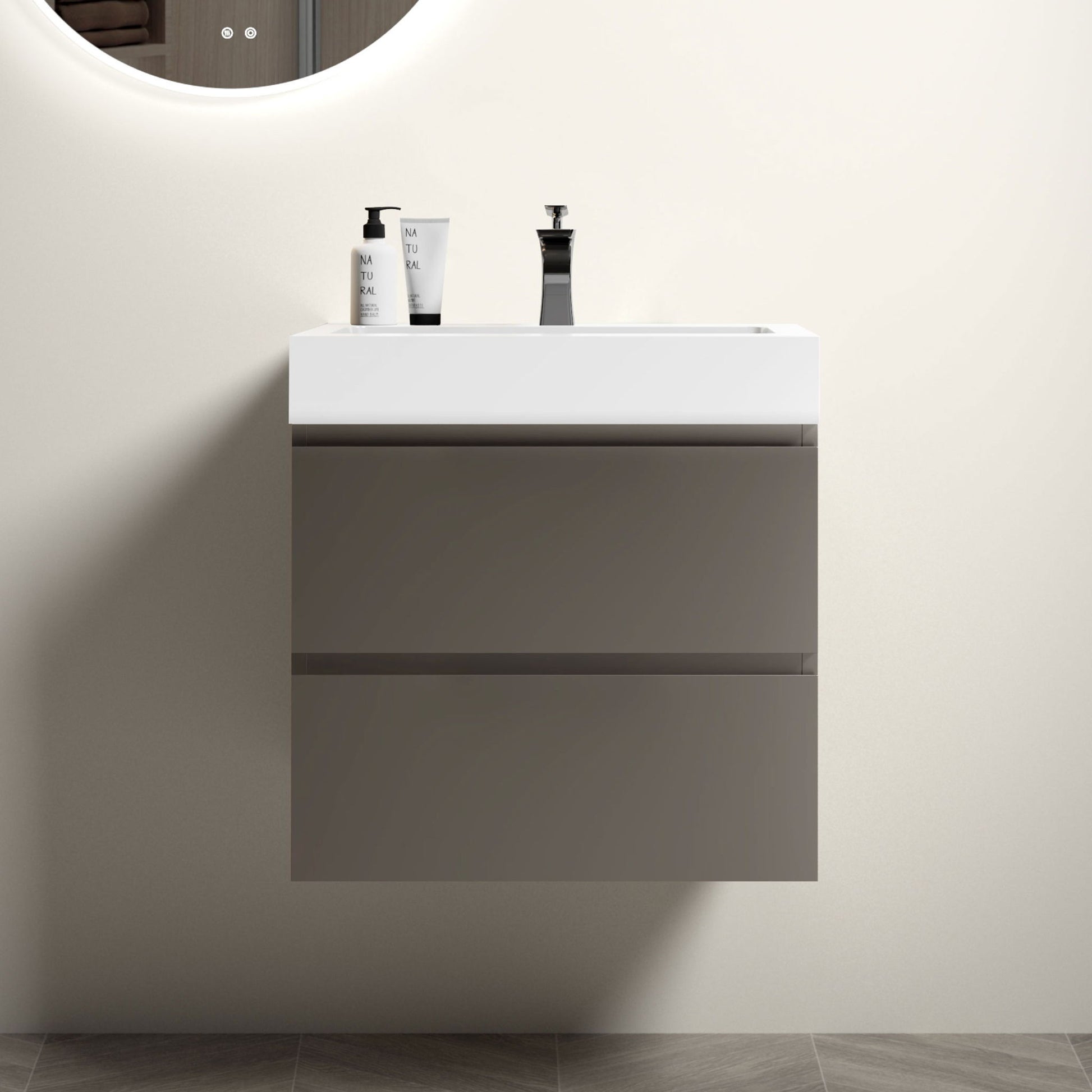 The Alice Bathroom Vanity features a modern, wall-mounted design with large gray drawers and a one-piece white basin, set against a light wall with a round mirror above. Drain and faucet not included.