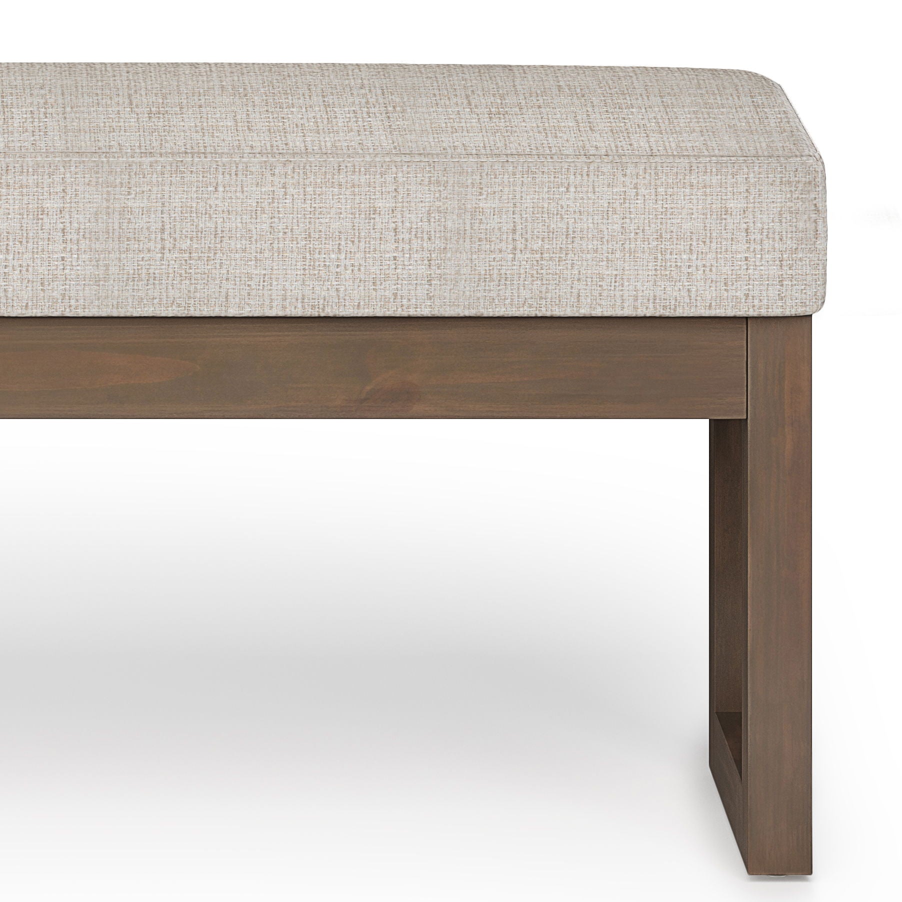 A close-up of the Milltown - Upholstered Ottoman Bench, featuring a light beige cushion and wooden square-leg base, set against a white background.