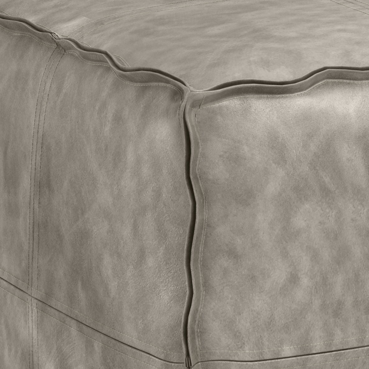 Close-up view of the corner of the Brody - Versatile Square Pouf in gray leather, highlighting its detailed stitching and textured material.