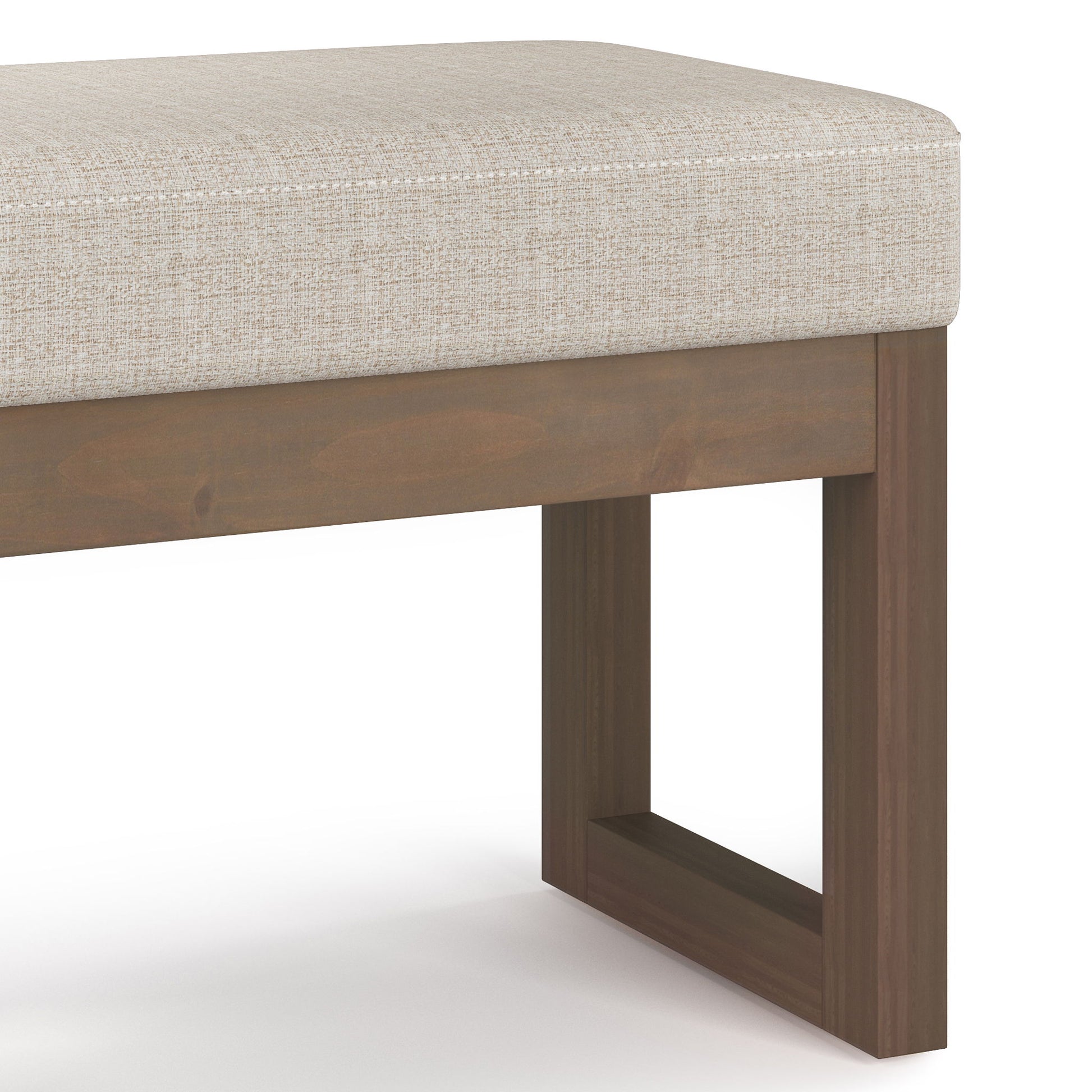 The Milltown Upholstered Ottoman Bench features a light beige cushion and a wooden base with simple rectangular legs, offering a modern, minimalist design.