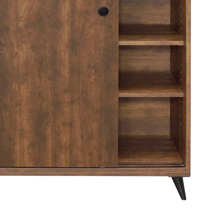 The Waina Shoe Cabinet in Oak features a sliding door with a round black handle, three right-side shelves, and dark angled legs.