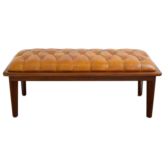 The Arden Bench With Buttons features rustic tan leather upholstery, button tufting, and dark wooden legs, shown from the front against a white background.