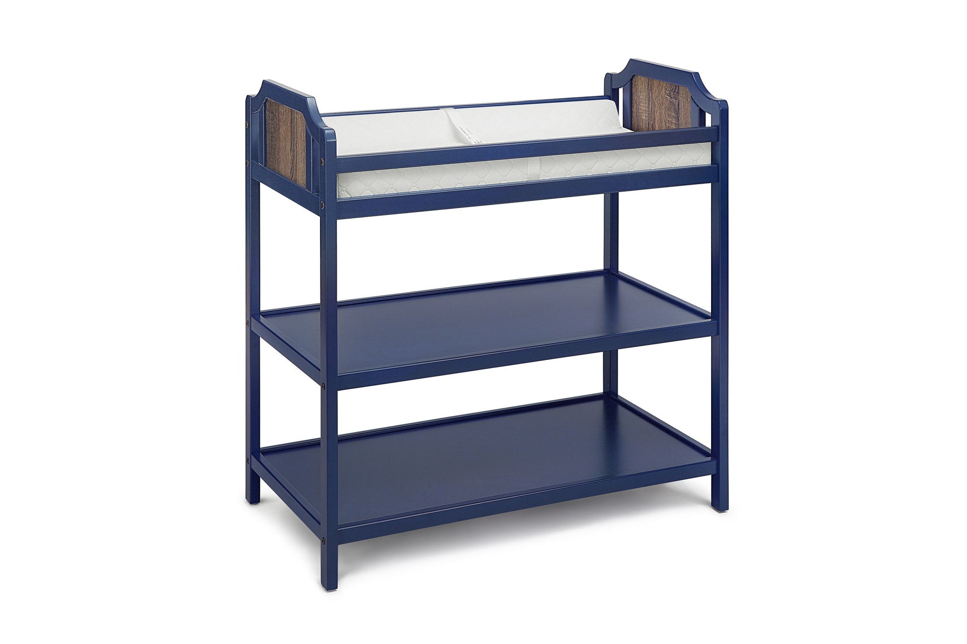 The Brees - Changing Table is navy blue wood, features two lower storage shelves, white cushioned changing pad on top, and wood accent panels at each end.