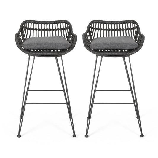 The Outdoor Rattan Bar Chair With Metal Legs features a woven rattan-style back, armrests, black metal legs, and dark gray seat cushions. Two chairs are shown facing forward on a white background.