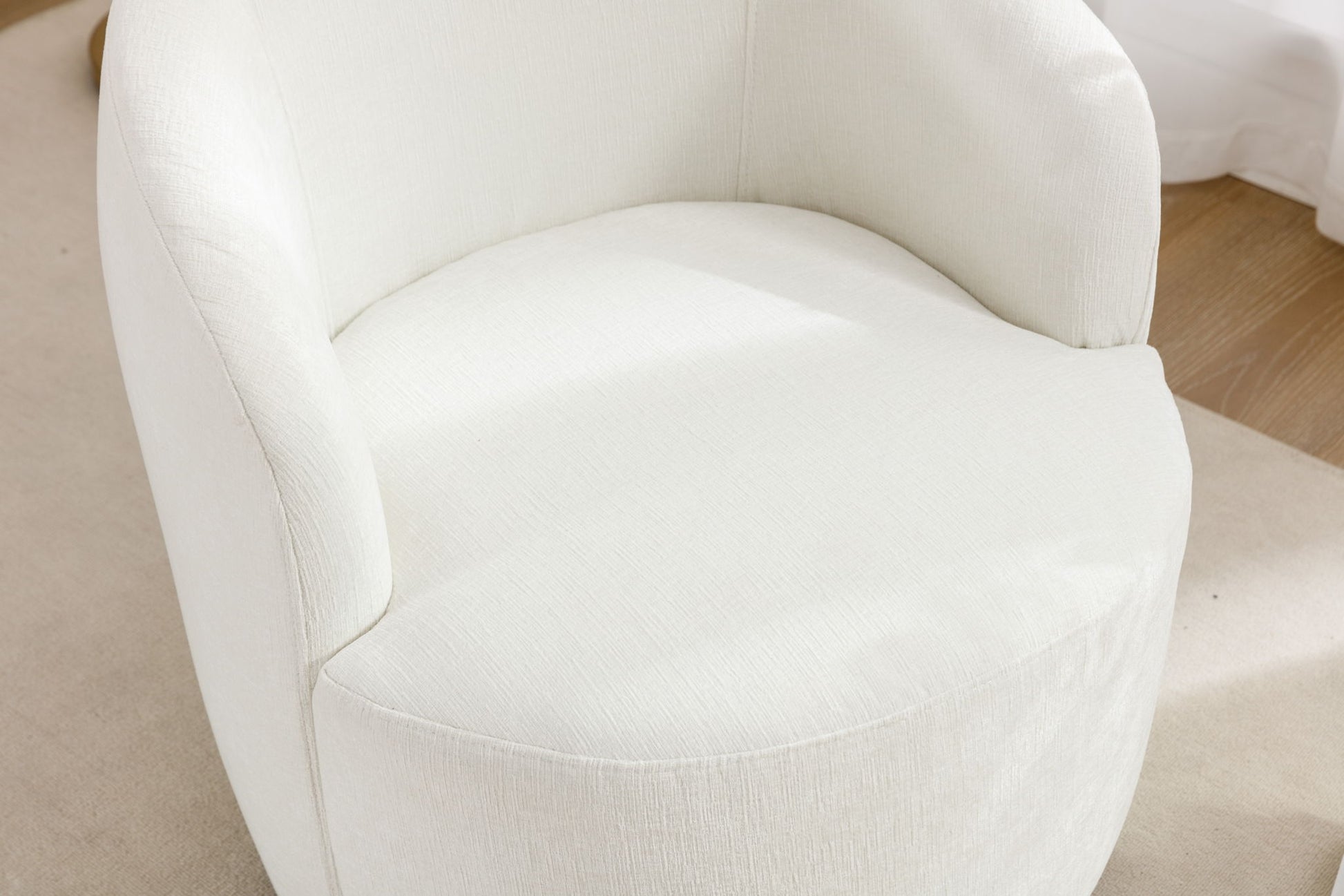 Close-up of the Chenille Fabric Swivel Accent Armchair Barrel Chair with a powder-coated metal ring, featuring modern curved design in off-white upholstery, set on a light floor and highlighted by natural light.