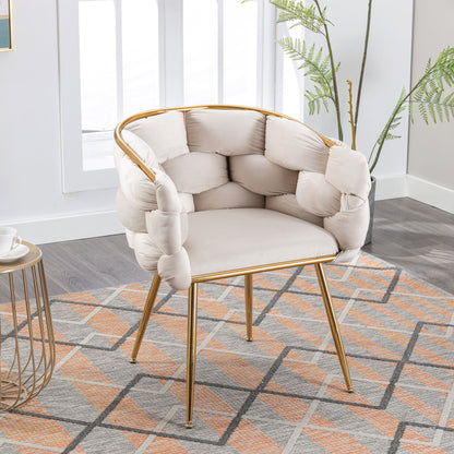 The Luxury Modern Simple Leisure Velvet Single Sofa Chair with gold legs and a tufted cream cushion is placed on a patterned rug beside a side table and potted plant in a bright, modern room.