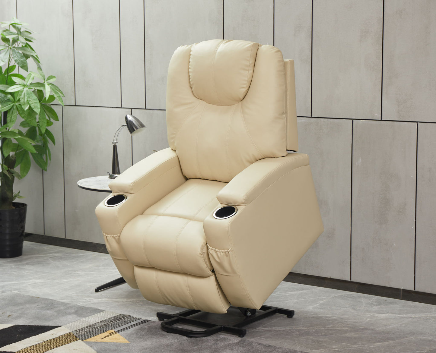 A Modern Recliner Chair With Cup Holders and Remote Control sits on a gray floor beside a small round side table, lamp, and green potted plant, set against a tiled wall.