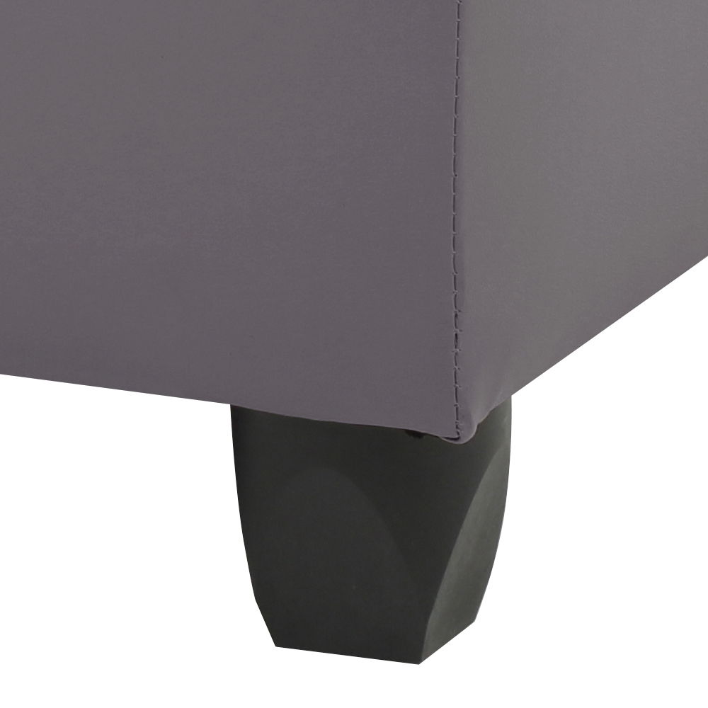 Close-up of the bottom corner of the Stylish Storage Contemporary Ottoman, upholstered in gray fabric, featuring a single dark tapered wooden leg against a white background.