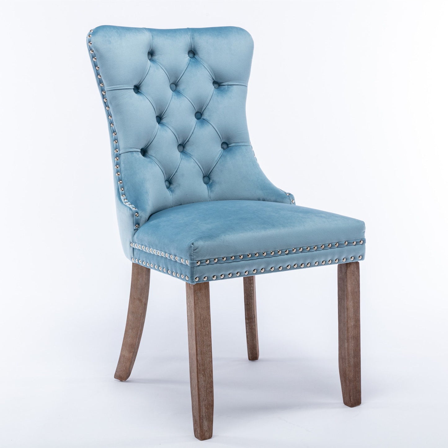 The Nikki set includes two modern, high-end velvet upholstered dining chairs with tufted backrests, silver nailhead trim, and solid wood legs, shown against a plain white background.