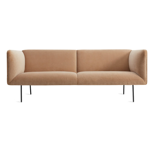 The Dandy Velvet Sofa in camel velvet features a modern, minimalist design with straight arms, cushioned seats, and thin black metal legs, set against a white background.