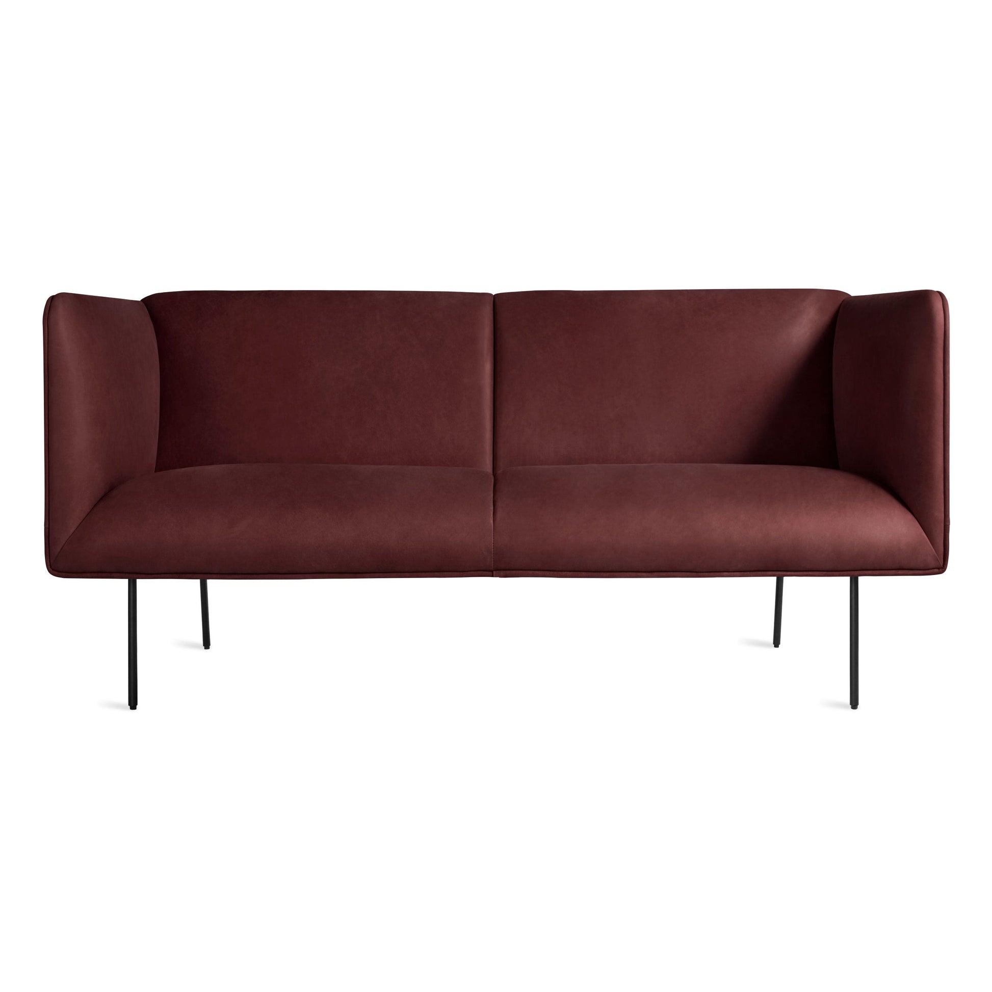 The Dandy Leather Studio Sofa in oxblood leather features a modern, minimalist design with high arms and slim black metal legs, shown against a plain white background.
