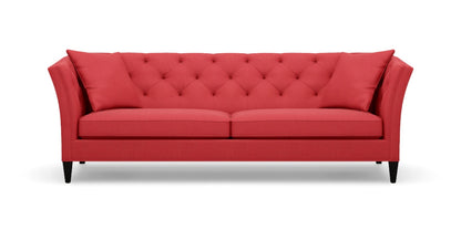 The Shelton 98" Sofa features a red color with a tufted backrest and two seat cushions, along with stylish flare arms. It rests on dark wooden legs and embodies a modern, elegant design.