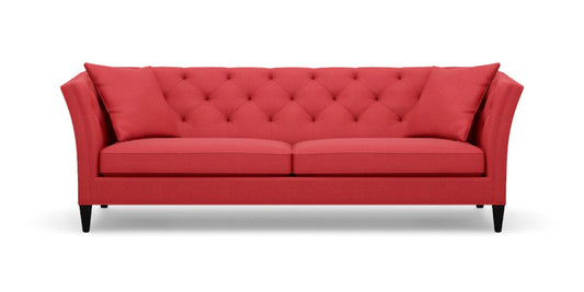 The Shelton 98" Sofa features a red color with a tufted backrest and two seat cushions, along with stylish flare arms. It rests on dark wooden legs and embodies a modern, elegant design.