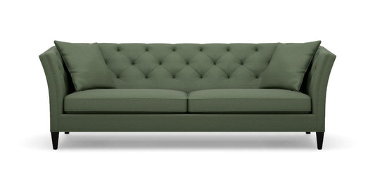 Introducing the Shelton 98" Sofa: a green tufted masterpiece accompanied by two matching cushions. This design boasts high arms and a sleek, modern aesthetic, complete with dark wooden legs and a cozy, plush appearance.