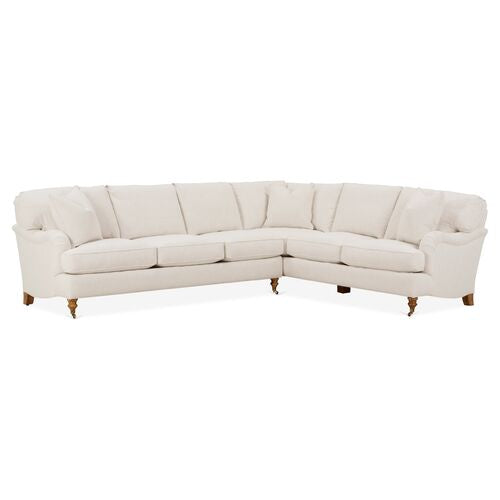 The Brooke 6-Piece Left-Facing Sectional is a spacious, L-shaped sofa with cream-colored upholstery. It includes cushioned backrests and seating, and rests on sturdy wooden legs.