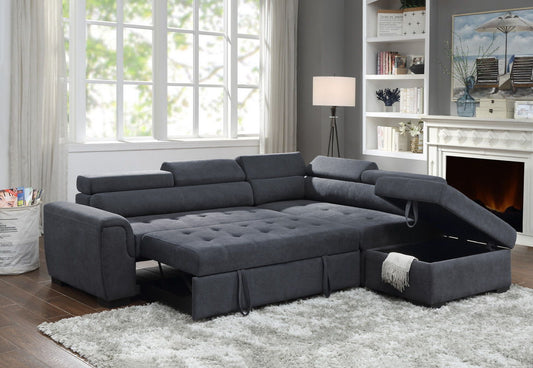 A modern living room features the Haris Fabric Sleeper Sofa Sectional with Adjustable Headrest and Storage Ottoman in dark gray on a white rug, near a fireplace, bookshelves, lamp, and large window.