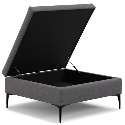 The Rebecca Multifunctional Coffee Table Storage Ottoman features a modern rectangular grey design, a lift-up lid for spacious storage, and stands on four slim black metal legs.