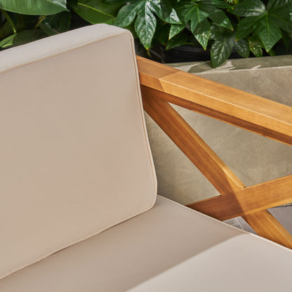 Close-up of the Alcove - L Shape Sofa Set, featuring beige cushions, a wooden armrest, and green leafy plants in the background.