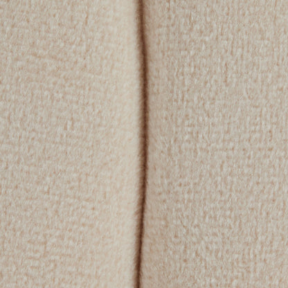 Close-up of the Braided - Versatile Round Ottoman shows its soft, beige, textured fabric with a vertical seam running down the center.