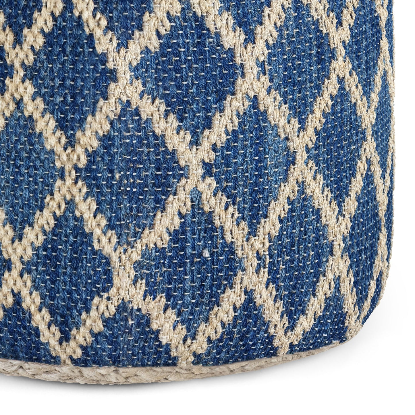 Close-up of the Edgeley - Handcrafted Round Pouf, featuring coarse woven fabric with a blue background and a cream diamond lattice pattern. The prominent stitches create a decorative, textured surface.