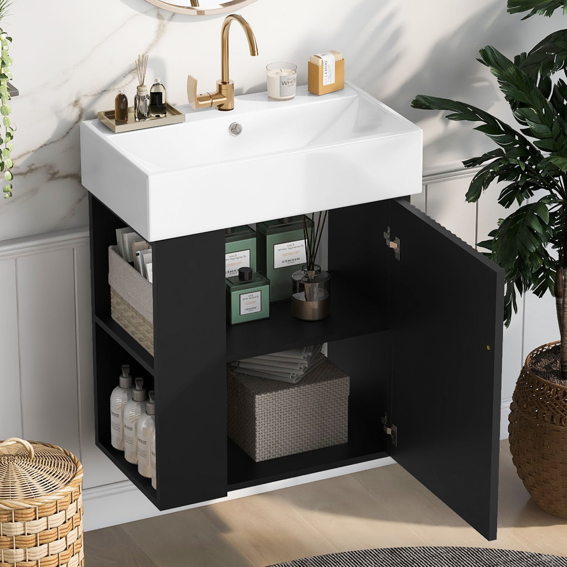 The Modern Floating Bathroom Vanity With Ceramic Basin is ideal for small bathrooms, featuring a white sink and sleek black cabinet with open shelves storing towels, baskets, and toiletries. Green plants and a wicker basket add a fresh touch nearby.
