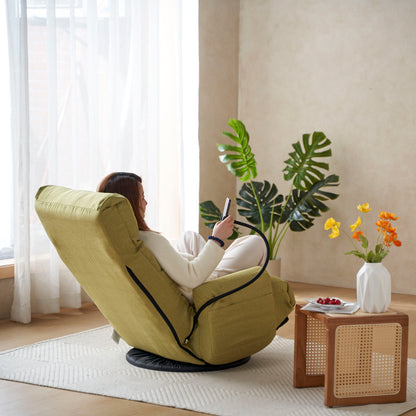 A person relaxes in an Adjustable Swivel Lounge Chair With 360 Degree Rotating Seat And Headrest Support by a window, checking their phone. Nearby are a small table with flowers, berries, a rattan cabinet, and lush green plants in the sunny room.