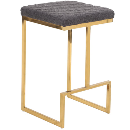 The Joel - Mid Century Modern Luxury Upholstered Stool features a gold metal frame, a square textured dark gray cushion, an open geometric design, and a convenient footrest for added comfort.