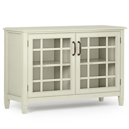 The Connaught - Handcrafted Low Storage Cabinet features a light wood finish, two glass-paned doors with a grid design, dark metal handles, interior shelving, and stands on four short legs.