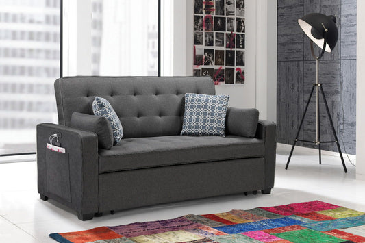 The William Modern Fabric Sleeper Sofa in gray, featuring 2 USB charging ports and 4 accent pillows, adds style to a bright living room with large windows, a black floor lamp, colorful patchwork rug, and a photo collage.
