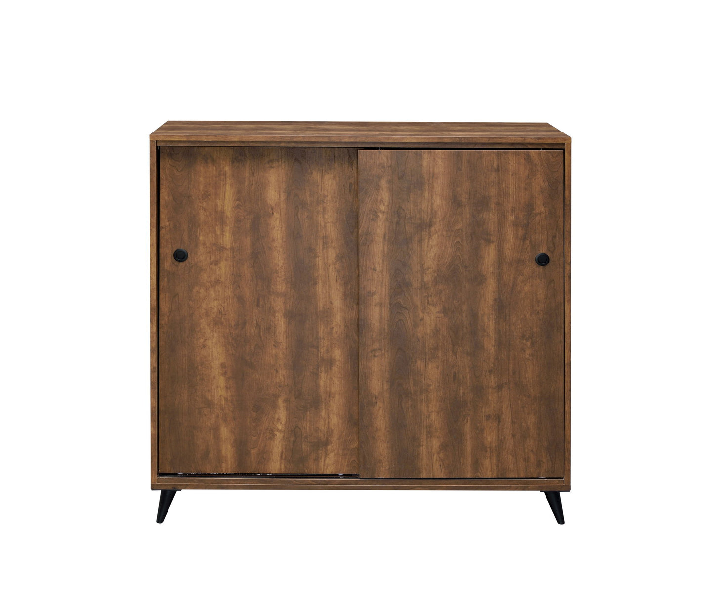 The Waina Shoe Cabinet in oak features a medium brown finish, two sliding doors with round black knobs, and four short black angled legs. Its simple, modern design makes it a stylish storage solution.