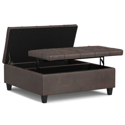 The Harrison - Large Coffee Table Storage Ottoman features a brown tufted cushion, split-top hinged lid for easy access to storage space inside, and stands on four short legs.