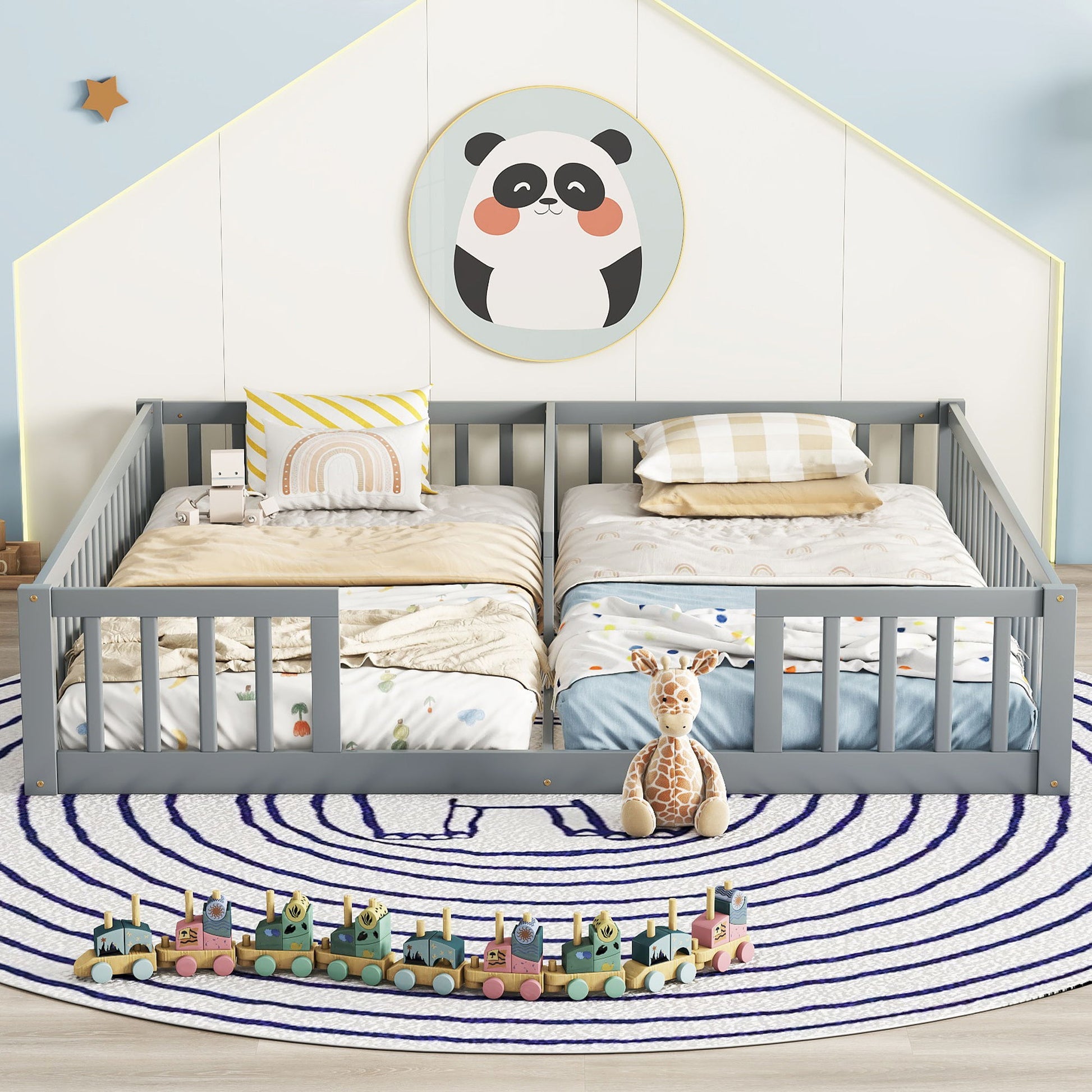 A cozy children’s bedroom features a Double Floor Bed With Fence, Guardrails, Without Door in gray, playful bedding, a plush giraffe toy, a wooden toy train on a round striped rug, and a panda picture hanging above the bed.