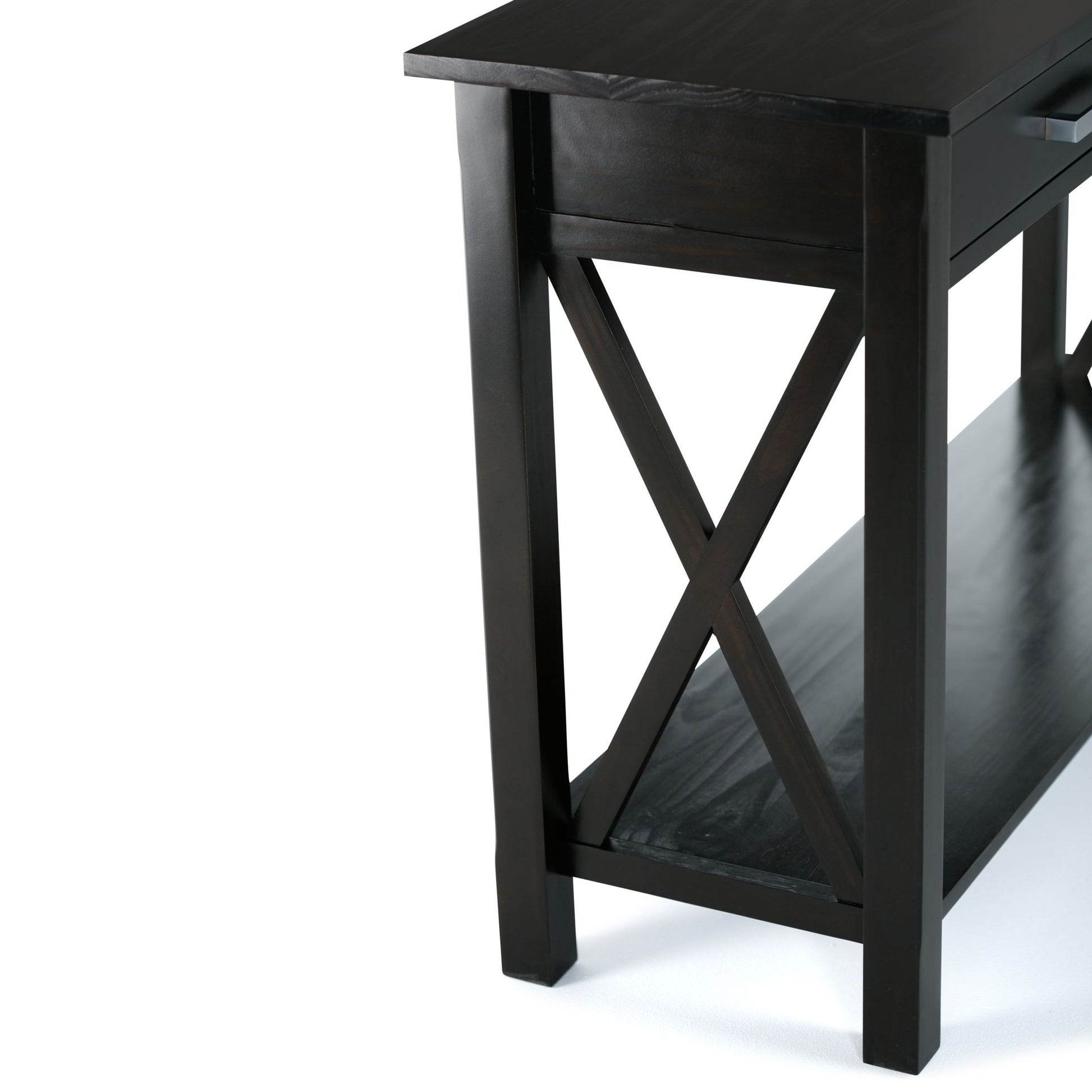A close-up of the Kitchener Handcrafted Table featuring dark wood, a lower shelf, straight legs, and X-shaped side supports set against a white background.