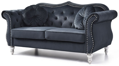 The Stylish Flared Arm Loveseat features a dark blue velvet finish, tufted back, silver stud accents, curved arms, two round pillows, and stands on four short silver legs.
