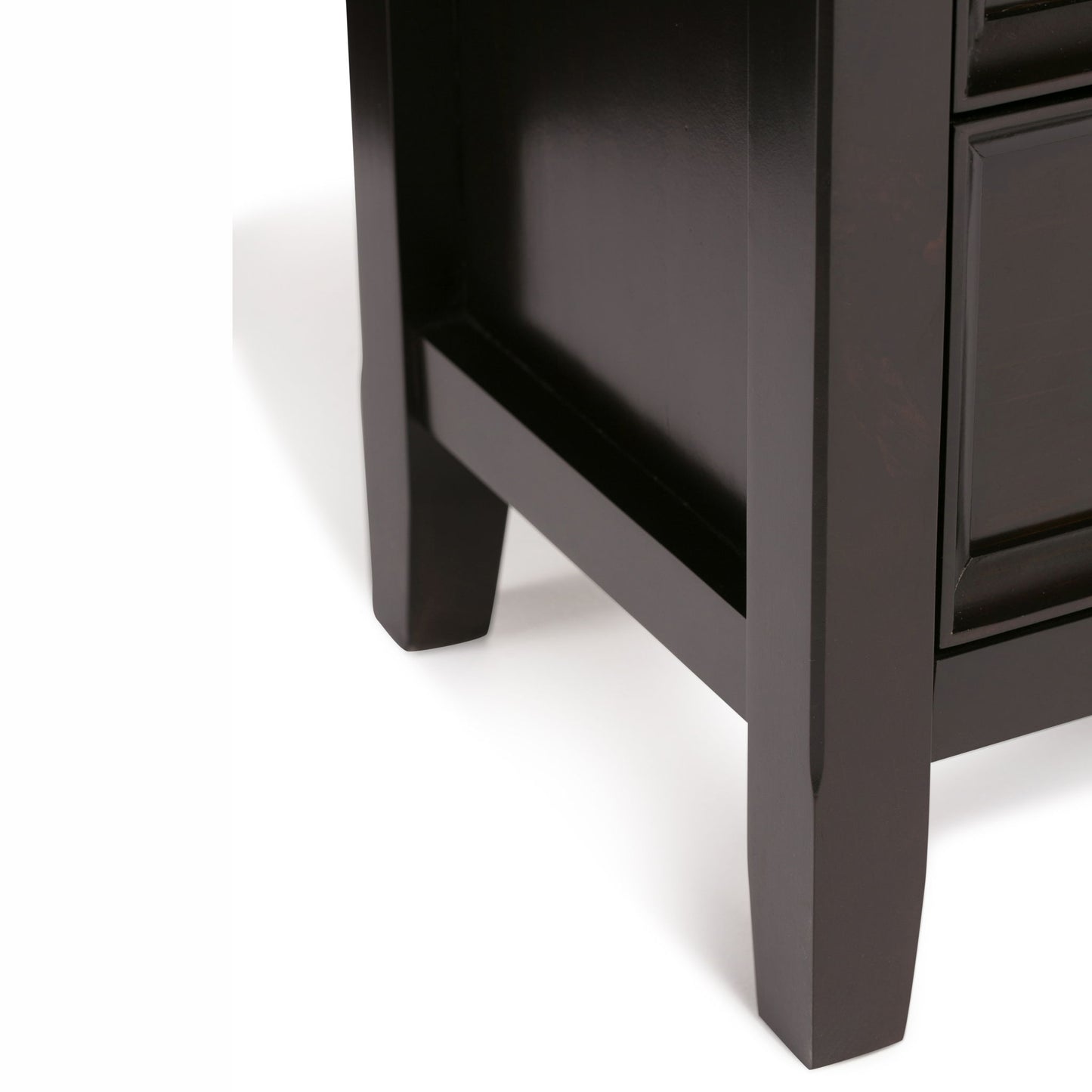 Close-up of the lower corner of the Amherst - Handcrafted Medium Storage Cabinet, highlighting two legs and part of the side and front panels against a plain white background.
