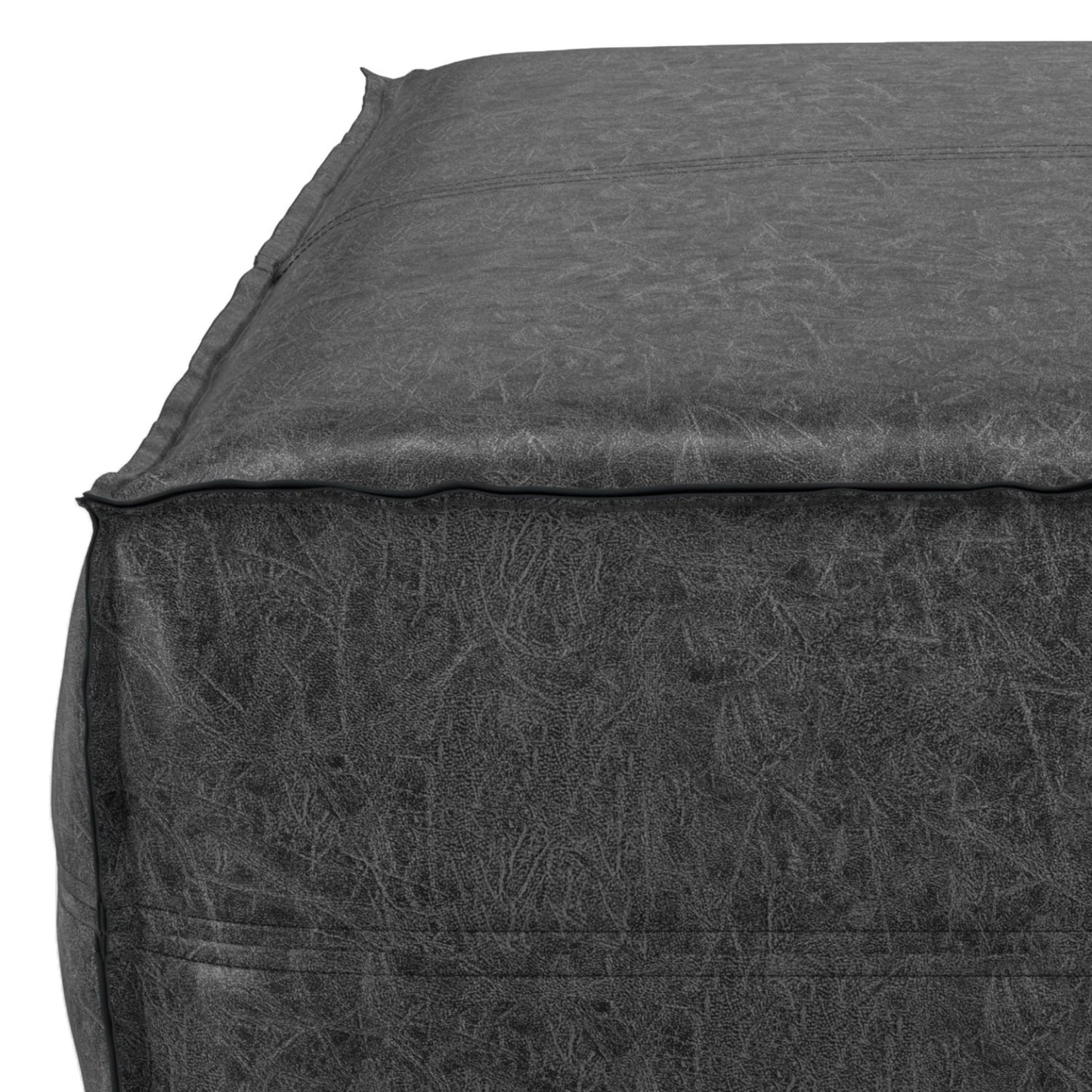 Close-up of the top corner of the Brody - Large Square, Coffee Table Pouf in dark gray, featuring detailed stitching and textured fabric along the seams.
