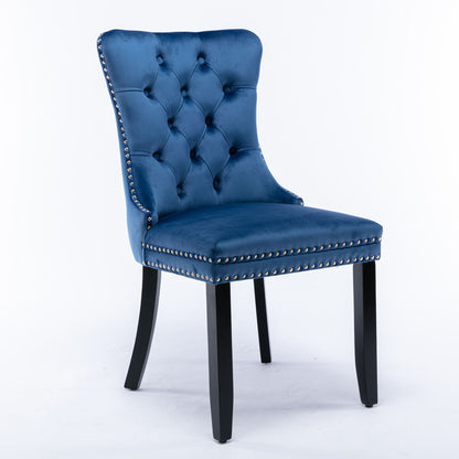 The Nikki set features two modern high-end velvet upholstered dining chairs with tufted backs, silver nailhead trim, and black wood legs, displayed against a plain white background.