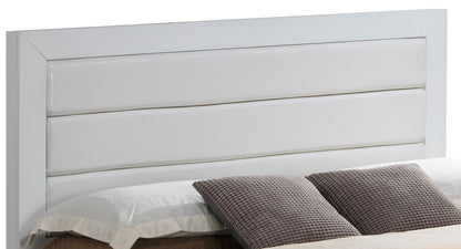 A close-up of the Transitional Modern Design Bed features a modern white headboard with horizontal padded panels, complemented by neatly arranged white pillows and textured gray accent pillows.