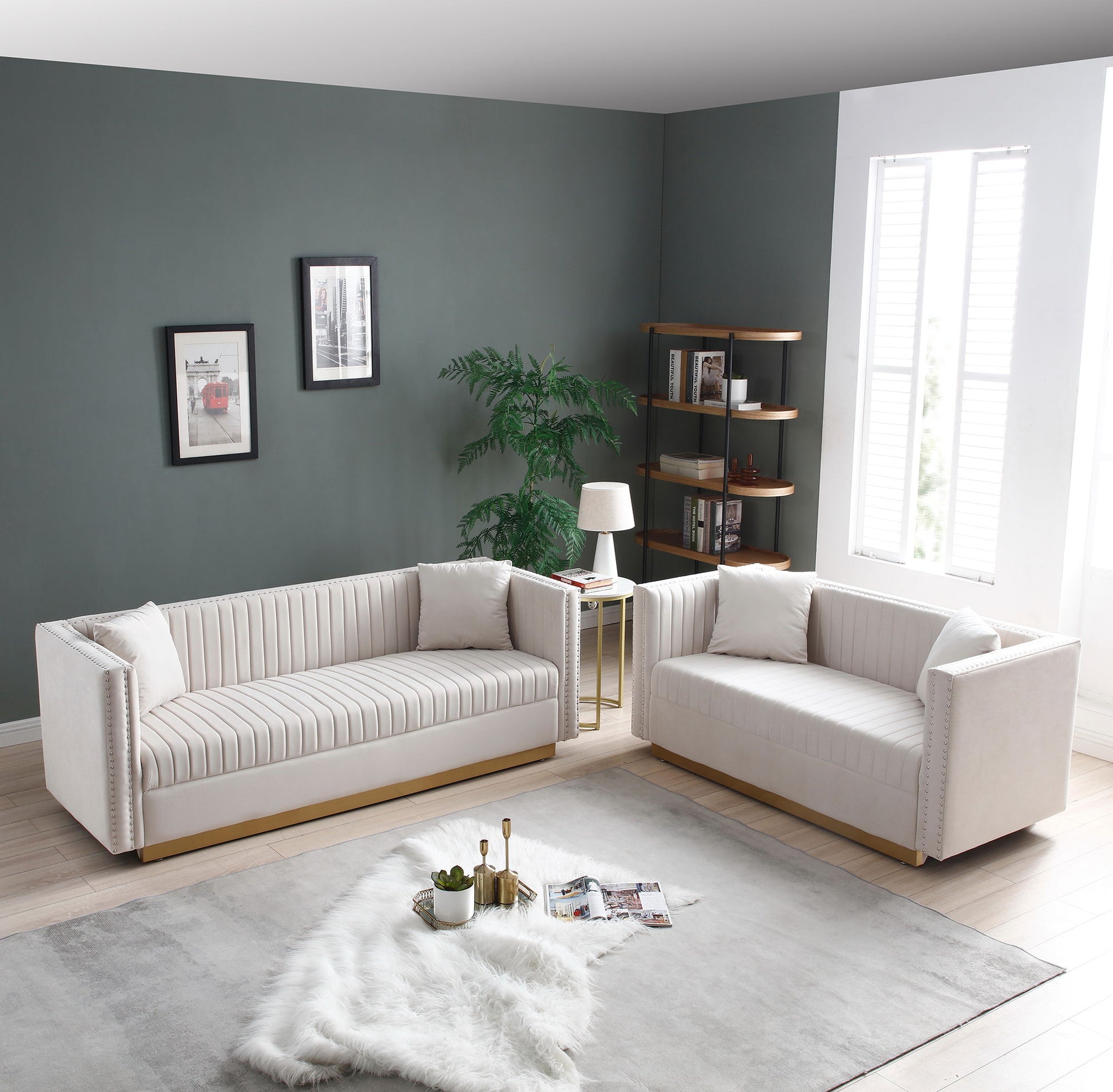 Modern living room with a 2-piece Contemporary Vertical Channel Tufted Velvet Sofa Loveseat set (includes 4 pillows), a light rug and fur throw, small lamp side table, potted plant, wall art, bookshelf, and window with white shutters.