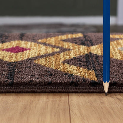 A sharpened blue pencil stands upright on a wooden floor beside the Tribes - GC_YLS4005 Southwest Area Rug, which features thin geometric patterns in yellow, brown, and red tones.