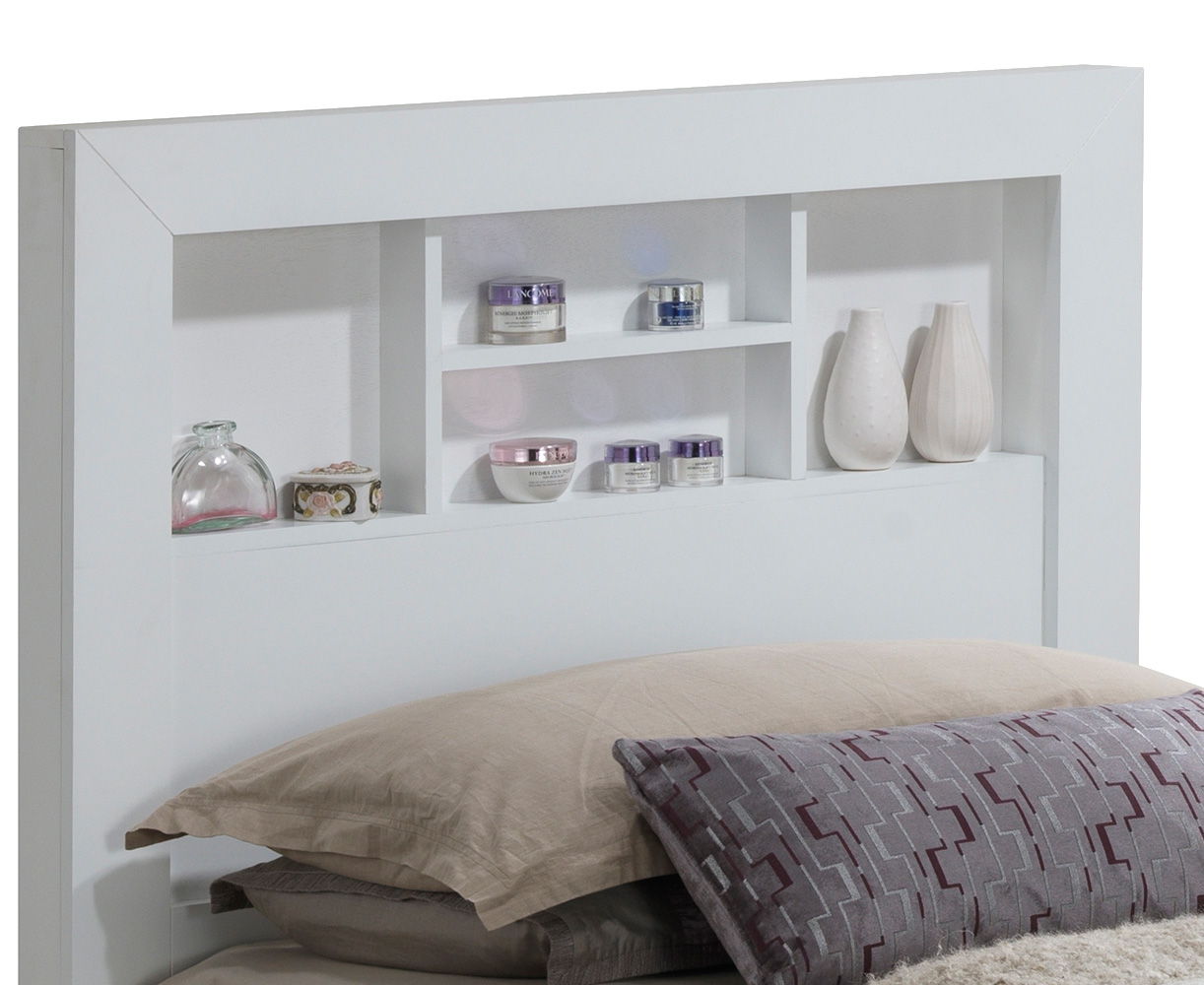 The Bed With Transitional Design Stylish features a white headboard with built-in shelves for vases, jars, or containers. The bed is styled with beige pillows and a patterned gray pillow in front.